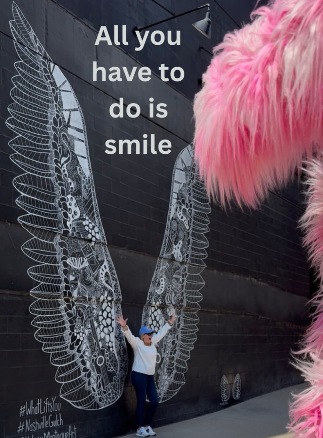 A lady in front of the Whatliftsyou wings mural in the Gulch, Nashville