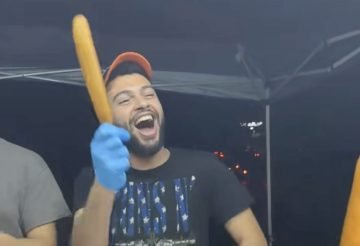 A picture of corndog guy, holding a corndog in Nashville.