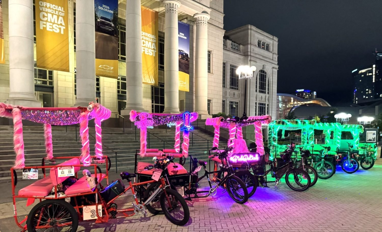 A fleet of pink and green pedicabs at the Schermerhorn Nashville. 