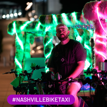 Male driver on a green furry pedicab in Nashville. 