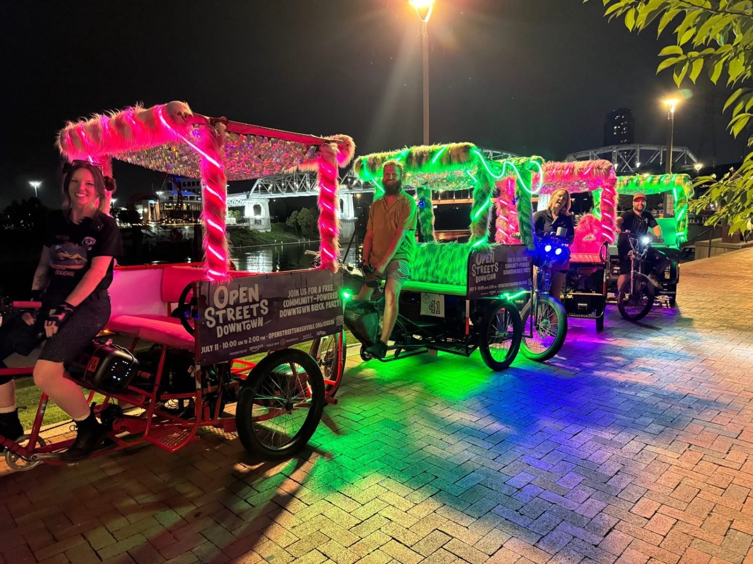 Pink and green neon pedicabs by the river front in Nashville Tennessee.